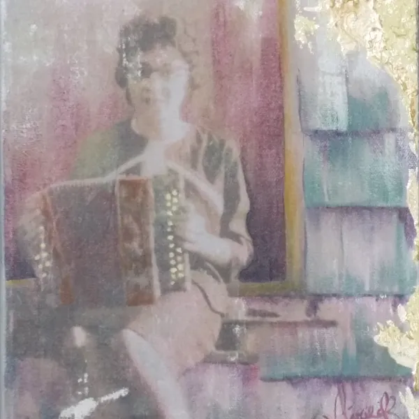 A woman sitting on the ground playing an accordion.