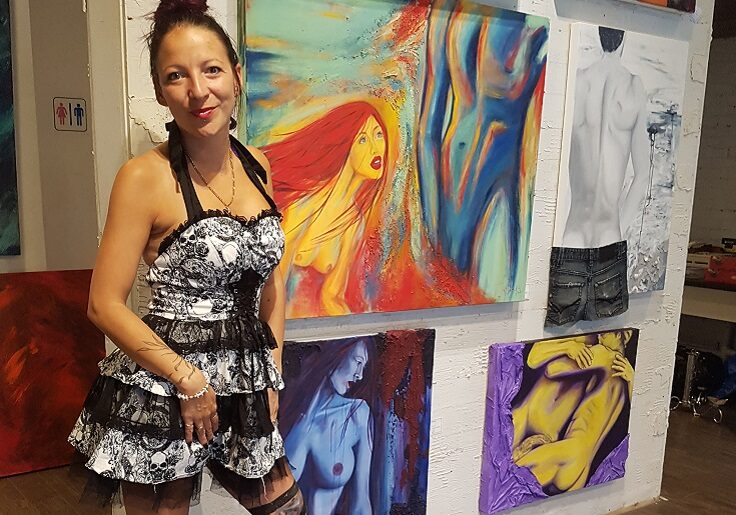 A woman standing in front of some paintings